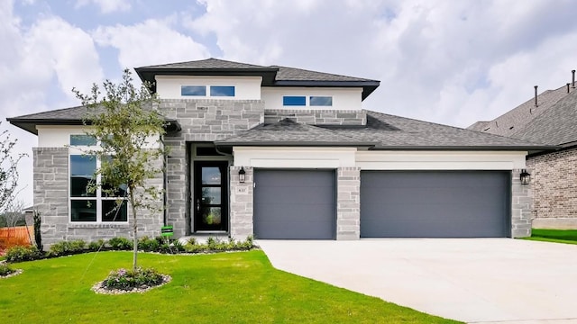 prairie-style house featuring a garage and a front lawn