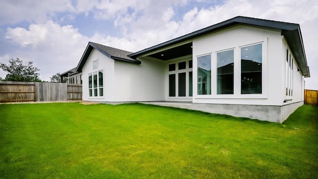 rear view of property featuring a yard