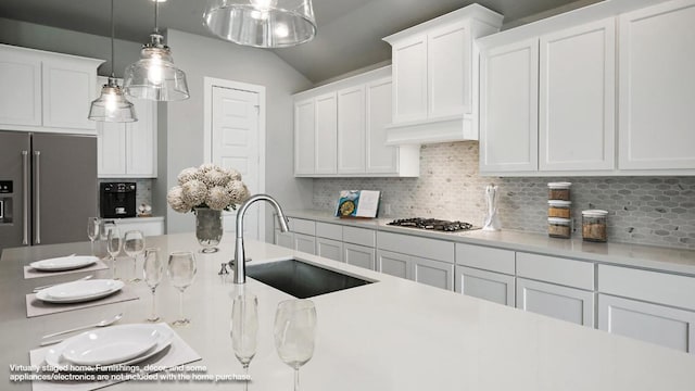 kitchen featuring appliances with stainless steel finishes, tasteful backsplash, sink, pendant lighting, and white cabinetry