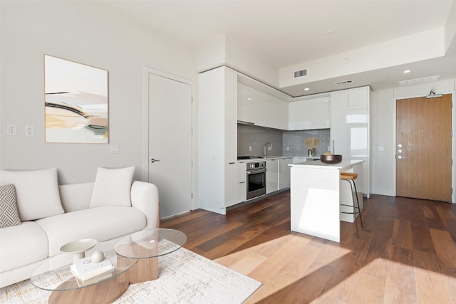 living room featuring sink and hardwood / wood-style flooring