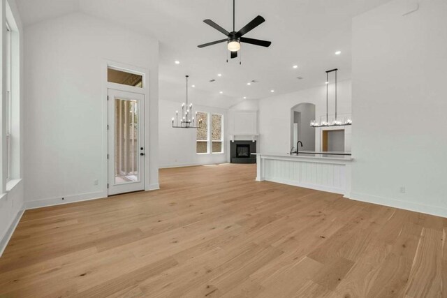 unfurnished living room featuring lofted ceiling, sink, light wood-type flooring, and ceiling fan