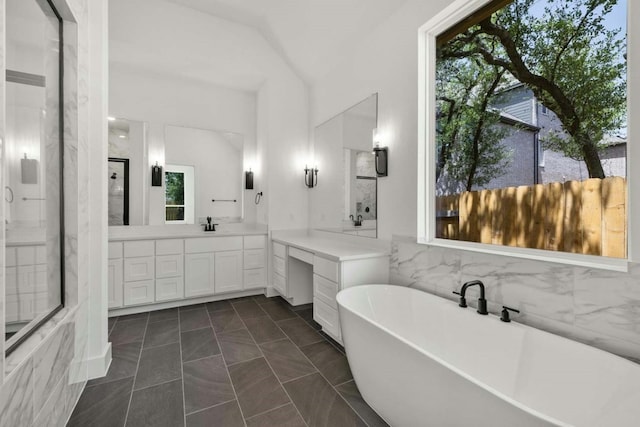 bathroom featuring vanity, a washtub, and tile patterned floors