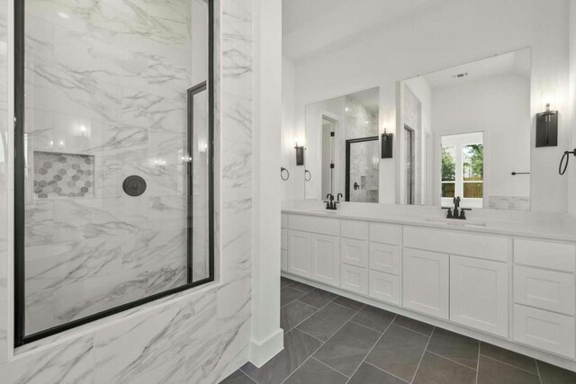 bathroom with dual vanity, tile patterned floors, and walk in shower