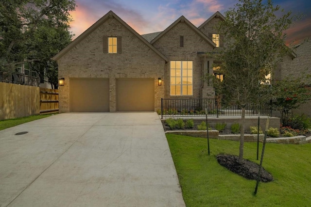 view of front of home featuring a garage and a yard