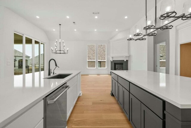 kitchen featuring stainless steel dishwasher, white cabinetry, sink, a wealth of natural light, and lofted ceiling