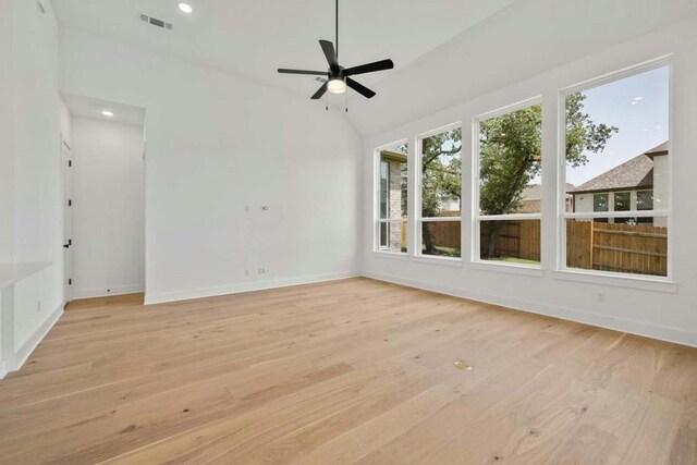 unfurnished room featuring light hardwood / wood-style floors, ceiling fan, and vaulted ceiling