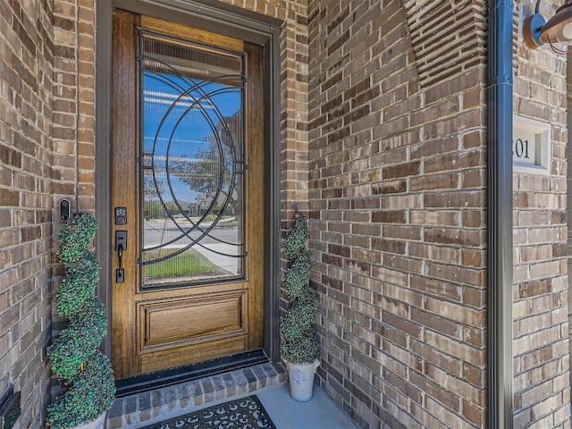 view of exterior entry with brick siding