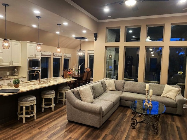 living area with dark wood-type flooring, recessed lighting, ceiling fan, and ornamental molding