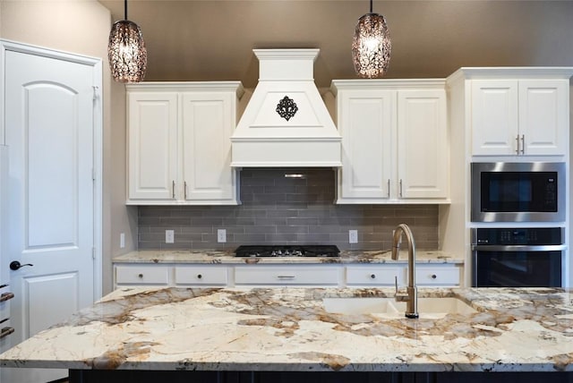 kitchen with wall oven, decorative backsplash, stainless steel microwave, gas stovetop, and a sink