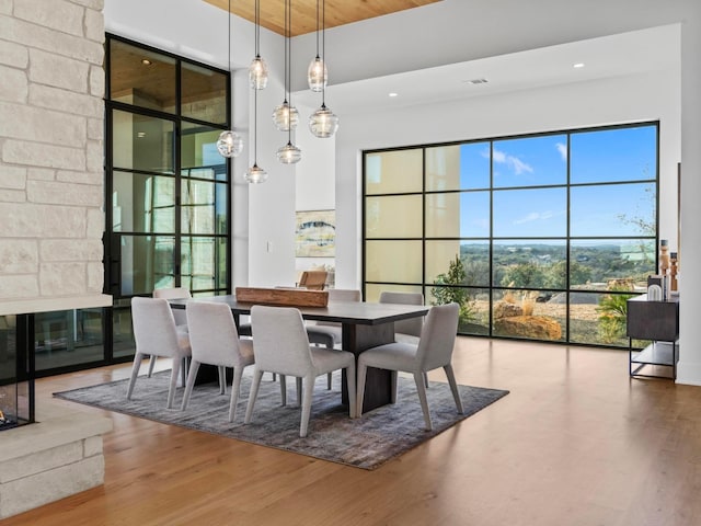 dining room with hardwood / wood-style flooring, a high ceiling, and wood ceiling