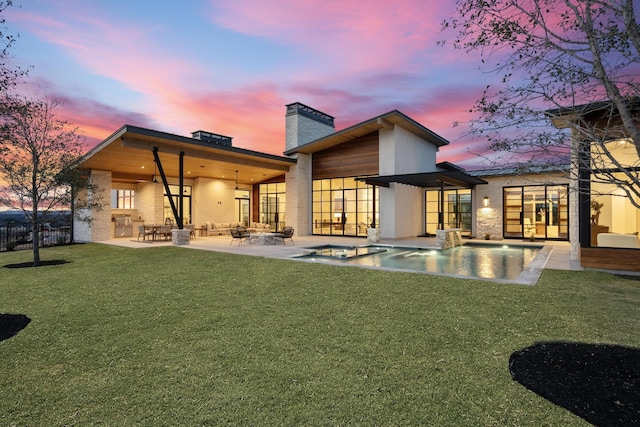 back house at dusk featuring a swimming pool with hot tub, a yard, ceiling fan, and a patio area