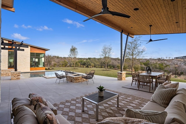 view of patio / terrace with ceiling fan, a swimming pool, and an outdoor living space with a fire pit