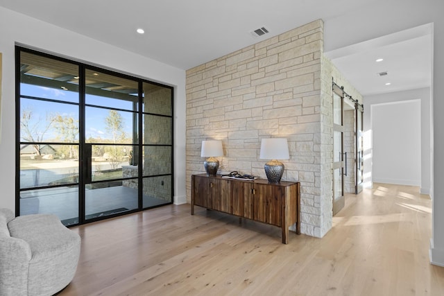 interior space with a barn door and light hardwood / wood-style flooring