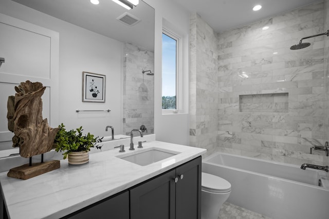 full bathroom with vanity, tiled shower / bath combo, and toilet