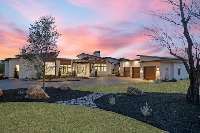 view of front of house featuring a garage and a lawn