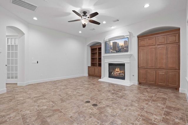 unfurnished living room featuring ceiling fan, built in features, and light tile patterned floors