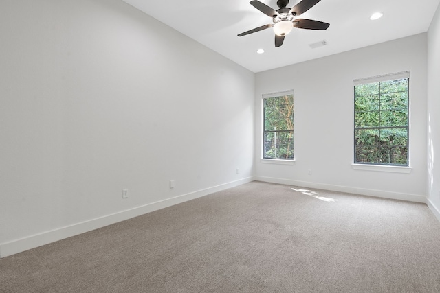 spare room featuring ceiling fan, plenty of natural light, and light colored carpet