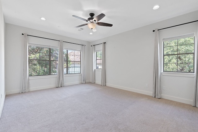 spare room featuring ceiling fan and light carpet