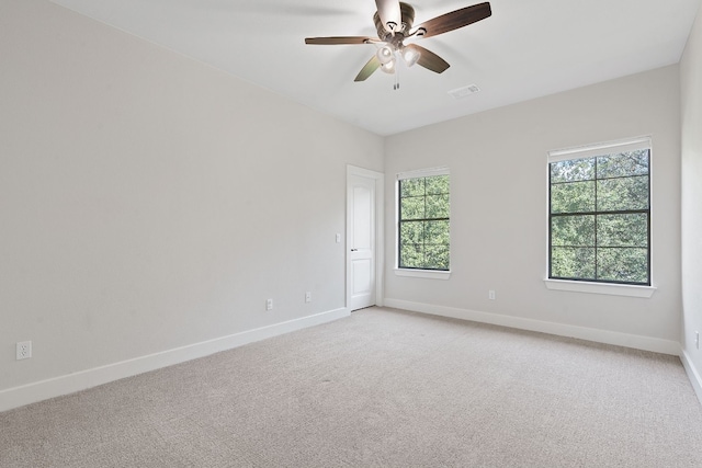 carpeted empty room featuring a wealth of natural light and ceiling fan