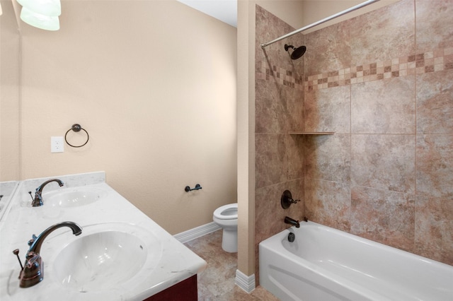 full bathroom with tile flooring, tiled shower / bath, toilet, and dual bowl vanity