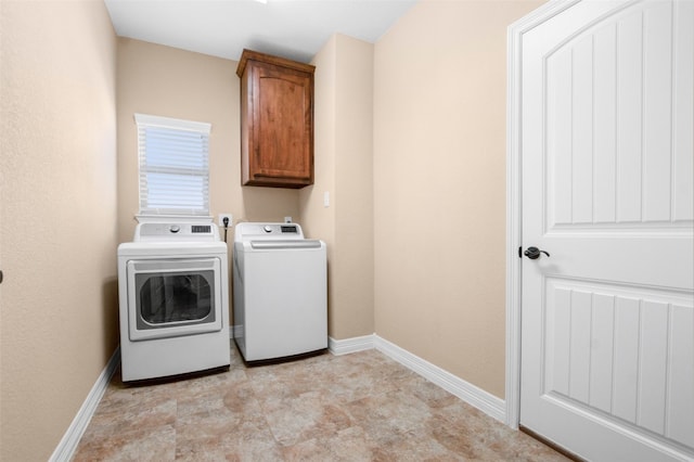 laundry room with cabinets, light tile floors, and washing machine and clothes dryer