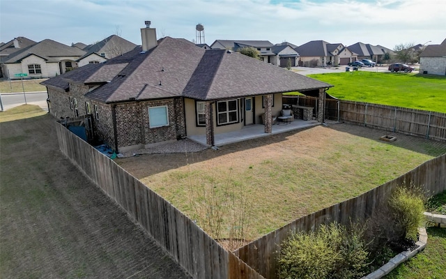 back of property with a yard and a patio area