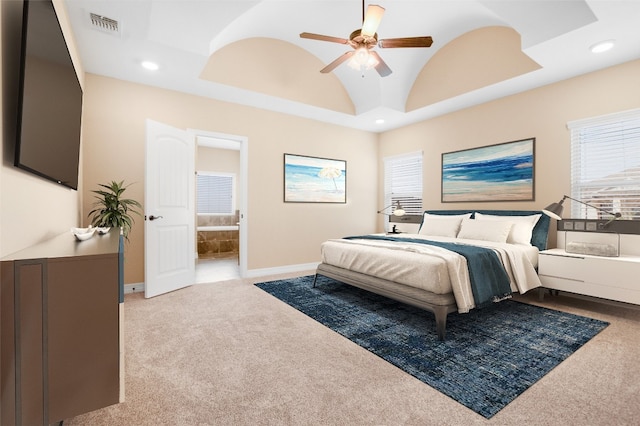 carpeted bedroom with ceiling fan, ensuite bathroom, and high vaulted ceiling