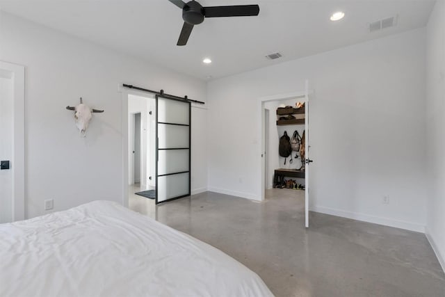 bedroom with ceiling fan and a barn door