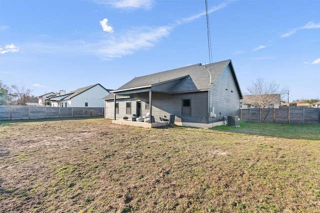 rear view of property with a lawn, a patio area, and central air condition unit