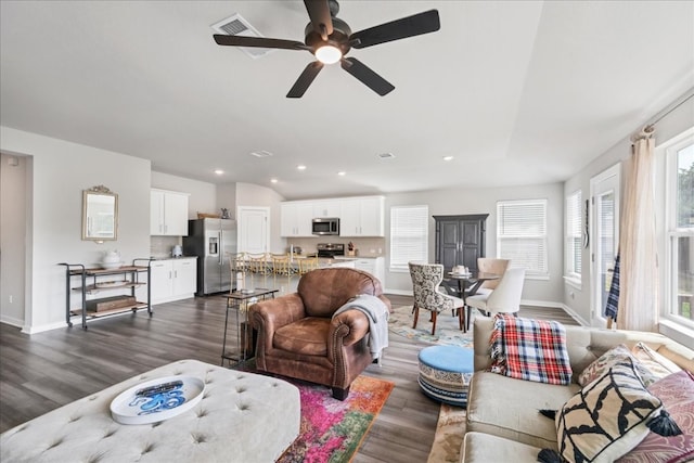 living room with a healthy amount of sunlight, dark hardwood / wood-style flooring, and ceiling fan