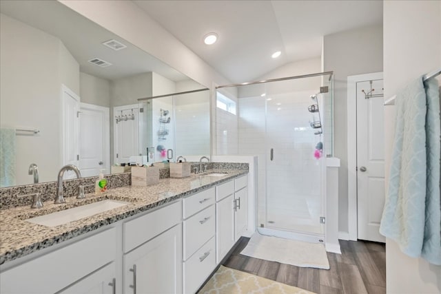 bathroom with lofted ceiling, wood-type flooring, dual vanity, and an enclosed shower