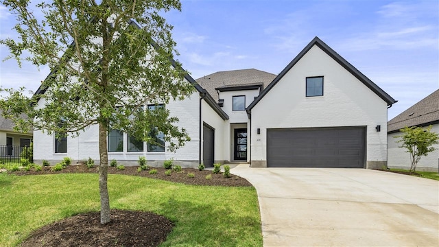 modern farmhouse featuring a garage and a front lawn