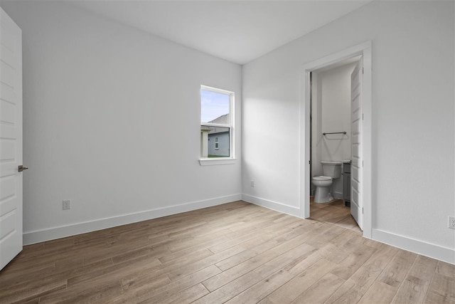 unfurnished bedroom featuring connected bathroom and light hardwood / wood-style flooring