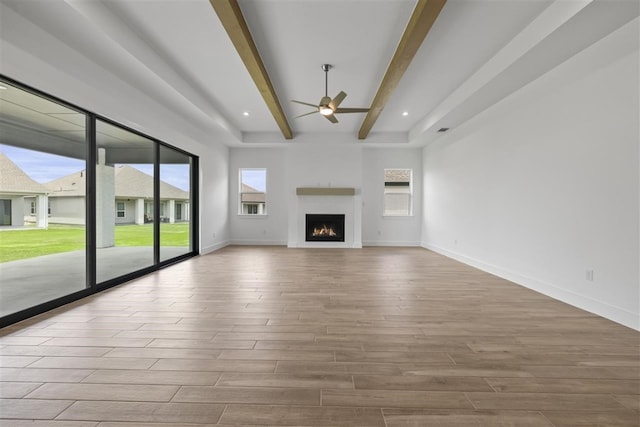 unfurnished living room featuring light hardwood / wood-style flooring, ceiling fan, and beam ceiling