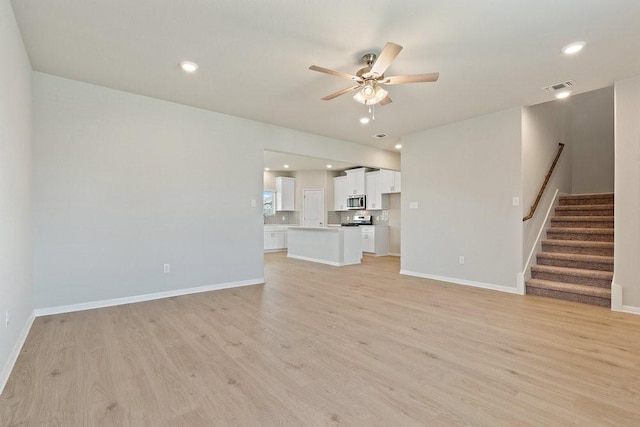 unfurnished living room featuring ceiling fan and light hardwood / wood-style flooring