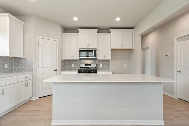 kitchen with a center island, white gas range oven, and light hardwood / wood-style floors