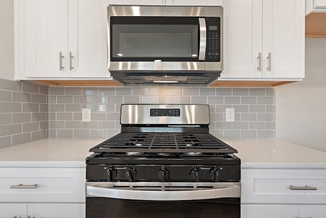 kitchen with backsplash, appliances with stainless steel finishes, light stone countertops, and white cabinets