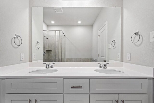 bathroom featuring vanity and a shower with shower door