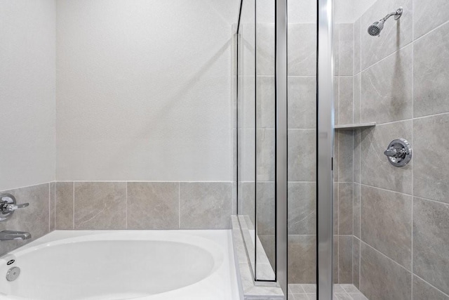 bathroom featuring shower with separate bathtub