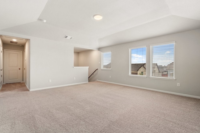 carpeted spare room with lofted ceiling