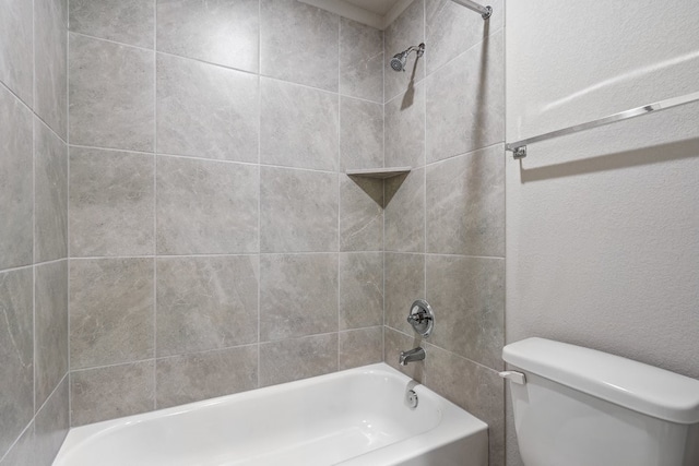 bathroom featuring toilet and tiled shower / bath combo