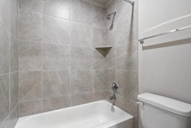 bathroom with tiled shower / bath and toilet