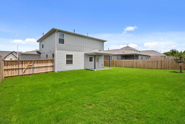 back of property with a yard and a patio area