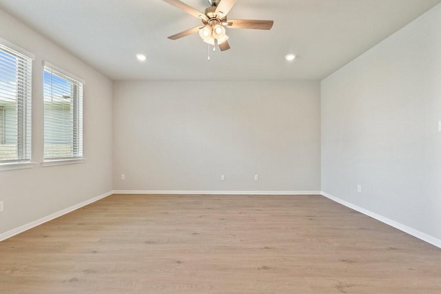 empty room with ceiling fan and light hardwood / wood-style floors