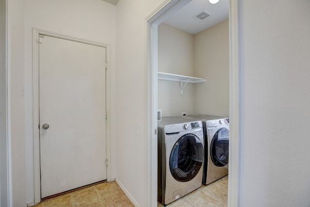 clothes washing area with laundry area, washer and clothes dryer, and visible vents