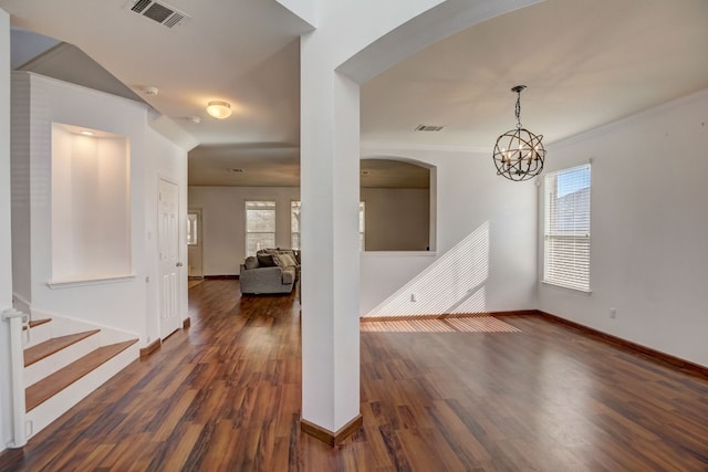 interior space with dark wood-style floors, baseboards, visible vents, and crown molding