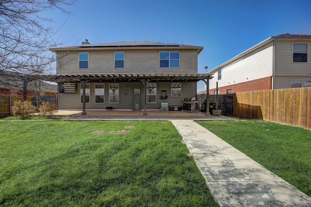 back of house featuring a patio area, solar panels, a lawn, and a fenced backyard