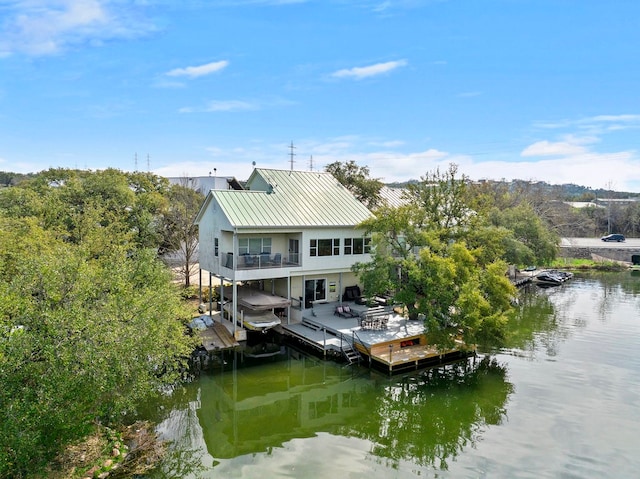 back of property with a water view and a balcony