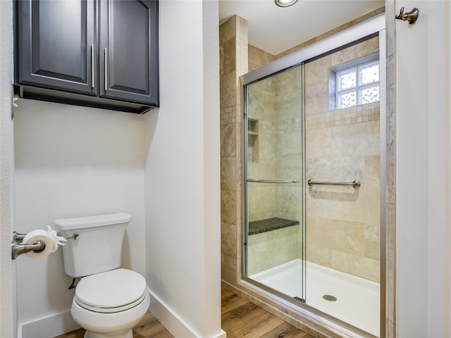 bathroom with toilet, hardwood / wood-style flooring, and an enclosed shower