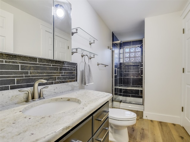 bathroom with oversized vanity, tasteful backsplash, toilet, and hardwood / wood-style flooring